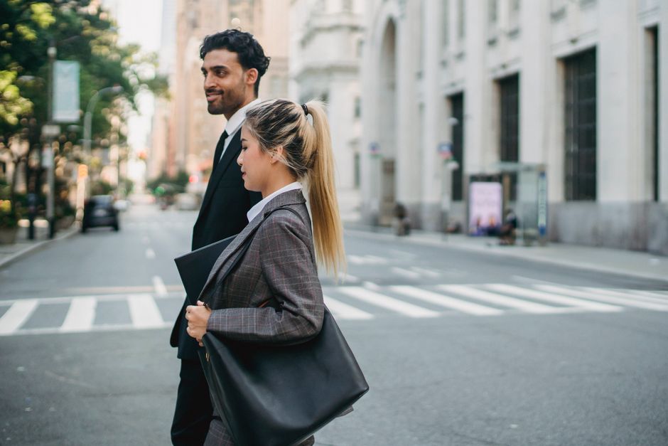 Business professionals walking confidently in a city street, showcasing teamwork and modern lifestyle.